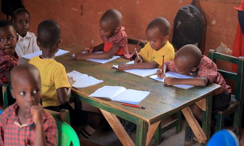 Children writing in their exercise books in class