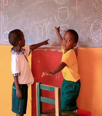 Two young children at the chalkboard