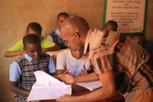 A volunteer teacher helping children with their schoolwork